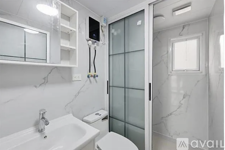 A bathroom with a sink, toilet, and glass shower door.