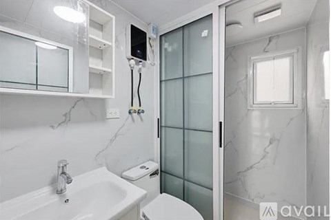 A bathroom with a sink, toilet, and glass shower door.