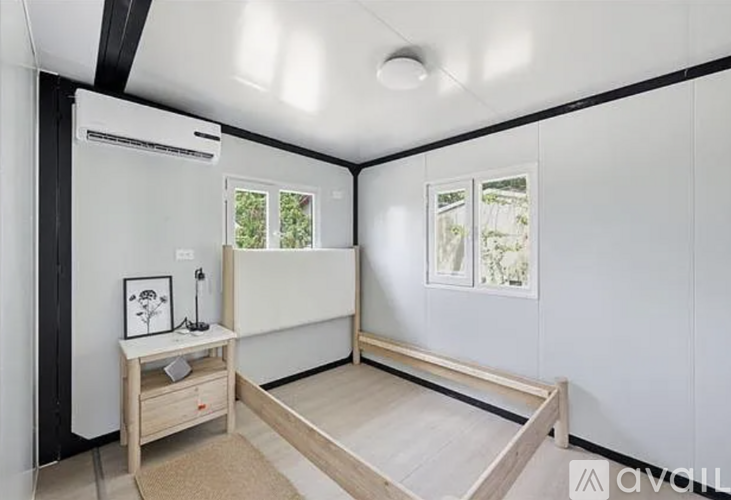A room with a bed, desk, and window.