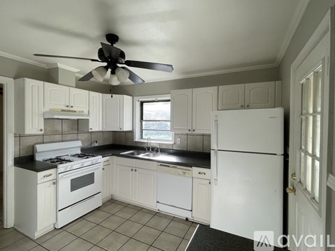 A kitchen with white appliances and cabinets.
