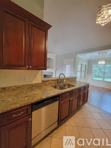 A kitchen with brown cabinets and a granite countertop.