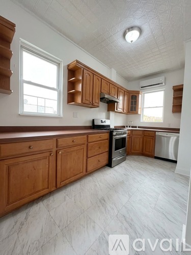 A kitchen with wooden cabinets and a white ceiling.