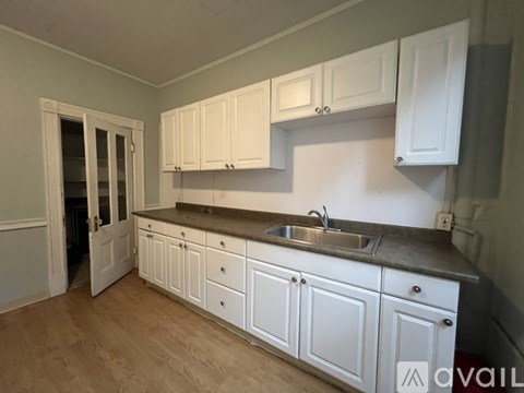 A kitchen with white cabinets and a sink.
