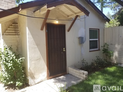 A house with a brown door and a window is for sale.