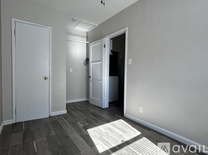 A room with a white door, a white cabinet, and a white closet.
