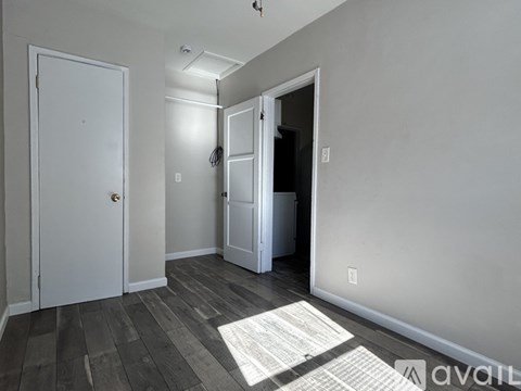 A room with a white door, a white cabinet, and a white closet.
