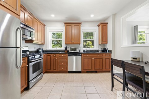A kitchen with wooden cabinets and a stainless steel refrigerator.