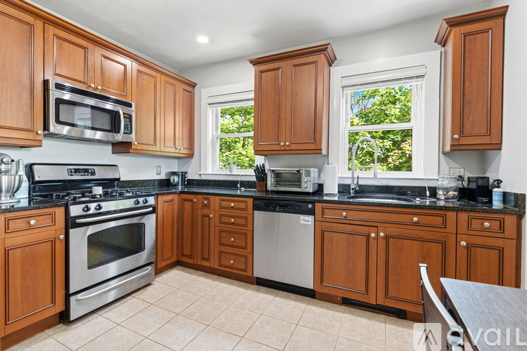 A kitchen with wooden cabinets and black countertops.