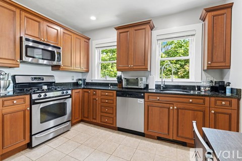 A kitchen with wooden cabinets and black countertops.