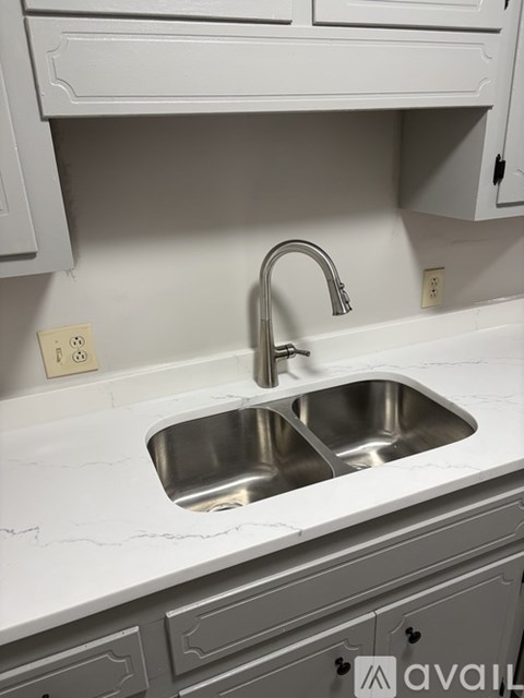 A kitchen sink with a chrome faucet.