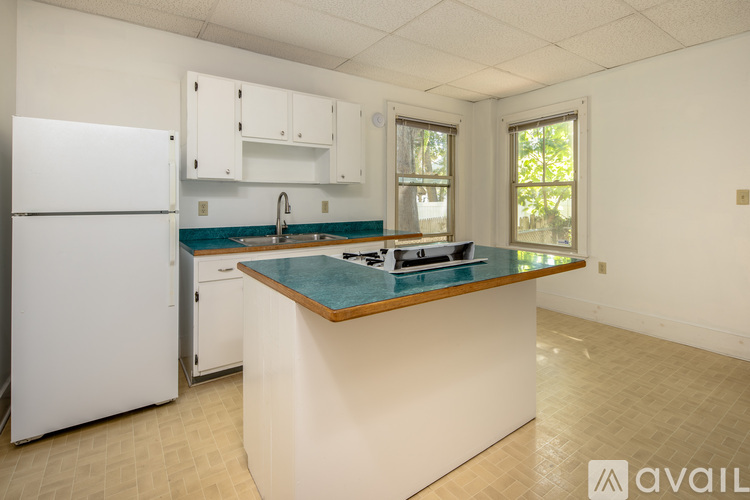 A kitchen with a white refrigerator and a countertop with a blue tile.