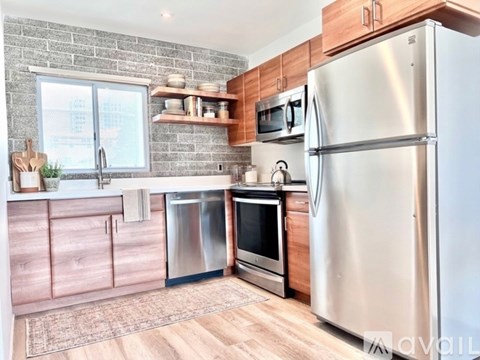 A kitchen with a refrigerator, oven, and sink.