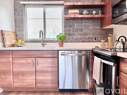 A kitchen with wooden cabinets and a stainless steel dishwasher.