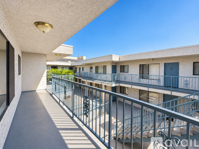 A balcony with a metal railing and a concrete floor.