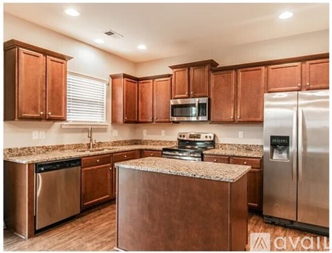 A kitchen with brown cabinets and stainless steel appliances.