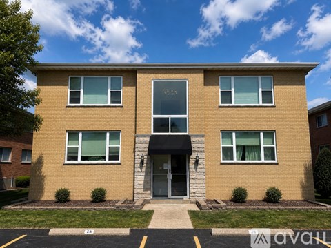 A two story brick building with a black awning and white trim.