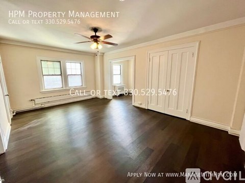 A room with a ceiling fan and a window, with text overlay for HPM Property Management.