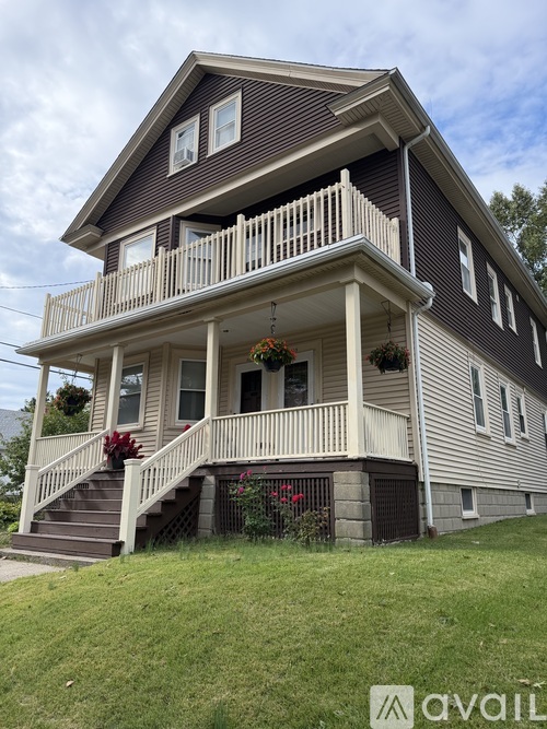 A two-story house with a balcony and stairs leading to the front door.