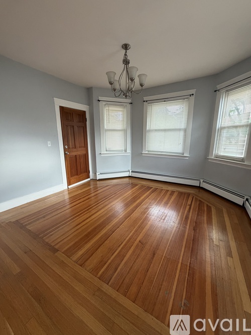 A room with wooden flooring and a chandelier.