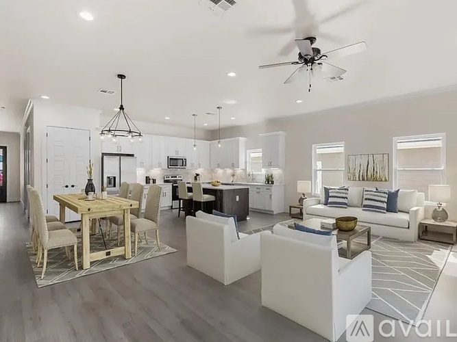 A spacious living room with a dining table and a kitchen in the background.