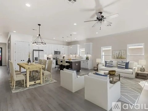 A spacious living room with a dining table and a kitchen in the background.