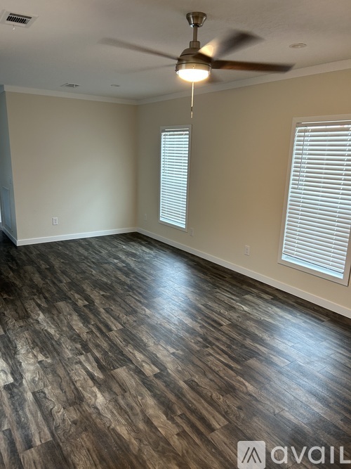 A room with wooden flooring and a ceiling fan.