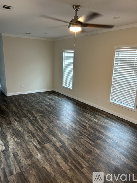 A room with wooden flooring and a ceiling fan.