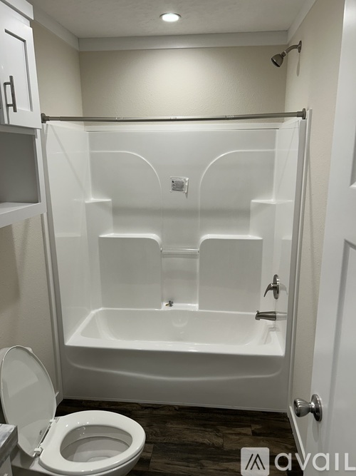 A white bathroom with a toilet and a walk in shower.