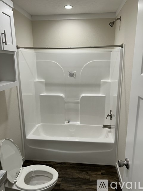 A white bathroom with a toilet and a walk in shower.