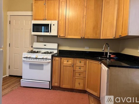 A kitchen with wooden cabinets and black countertops.