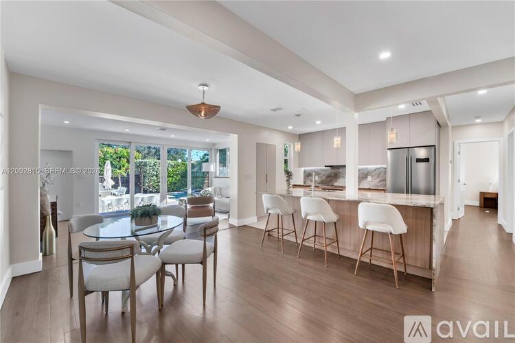 A modern kitchen with a dining table and chairs.