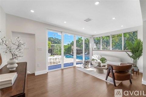 A living room with a pool visible through the sliding glass doors.