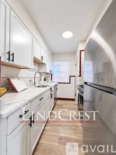 A kitchen with white cabinets and a counter top.