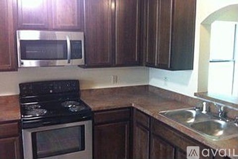 A kitchen with a black stove top oven and a microwave above it.