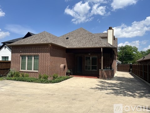 A house with a brown brick exterior and a grey roof.