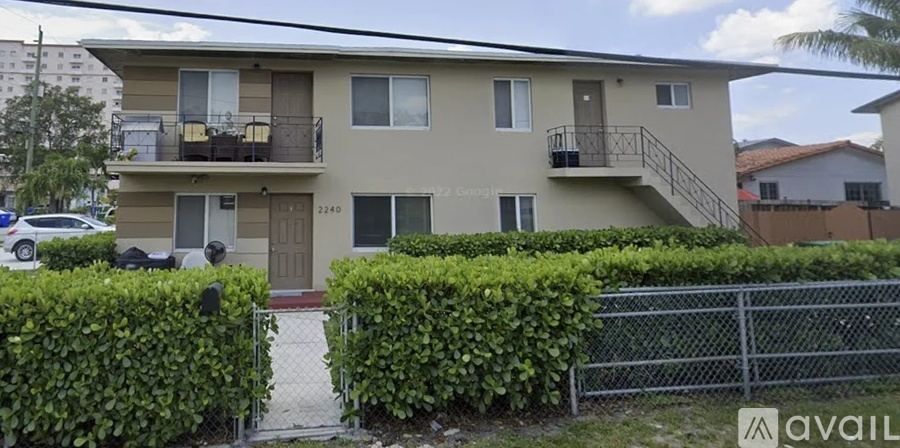 A two-story apartment building with a balcony on the second floor.