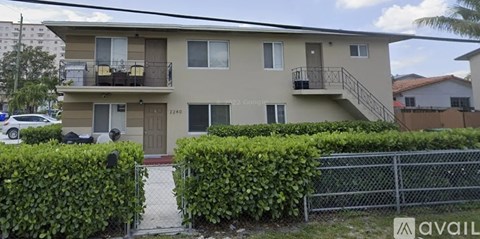 A two-story apartment building with a balcony on the second floor.