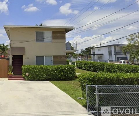 A house with a brown fence and a gate in front of it.