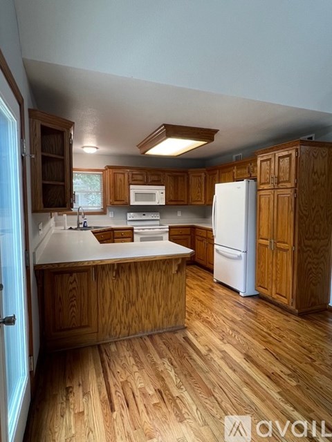 A kitchen with wooden cabinets and a white refrigerator.