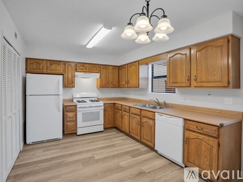 A kitchen with wooden cabinets and white appliances.