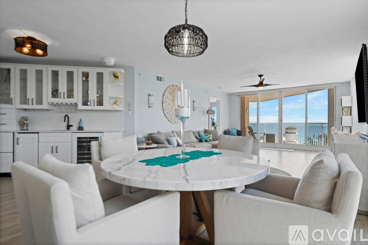 A modern dining room with a round table and white chairs.