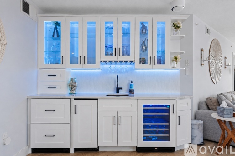A kitchen with white cabinets and a blue light.