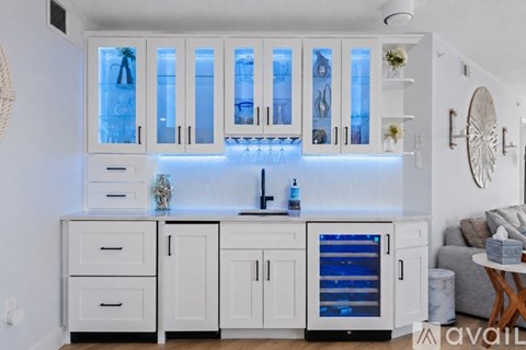 A kitchen with white cabinets and a blue light.