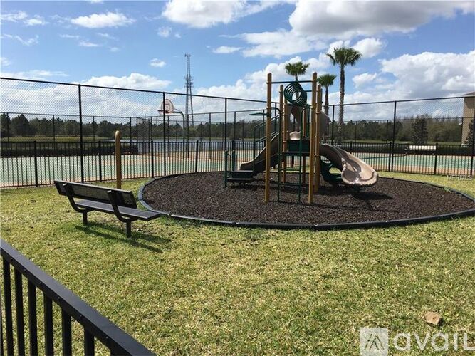 A playground with a slide, swings, and a basketball court.