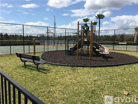 A playground with a slide, swings, and a basketball court.