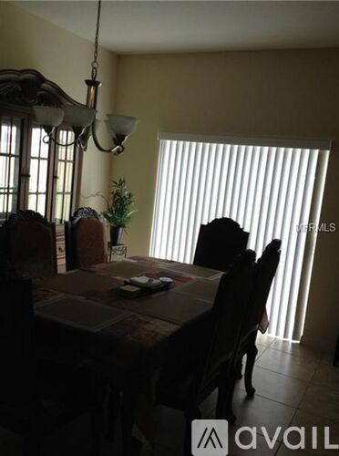 A dining room with a table and chairs.