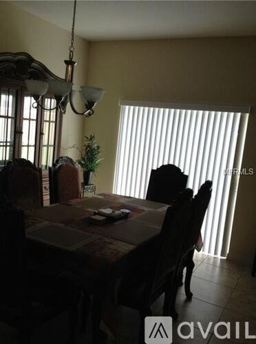 A dining room with a table and chairs.