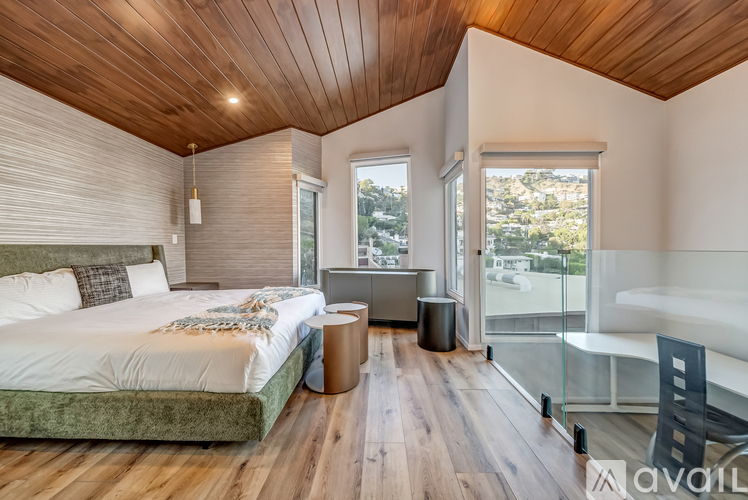 A bedroom with a large bed and a wooden ceiling.