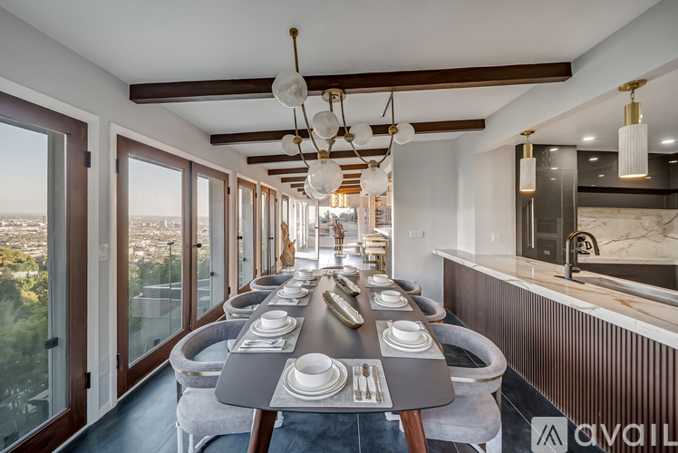 A modern dining room with a long table set for a meal.