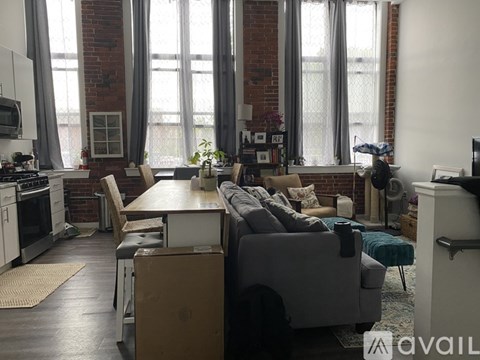 A living room with a grey couch and a wooden dining table.